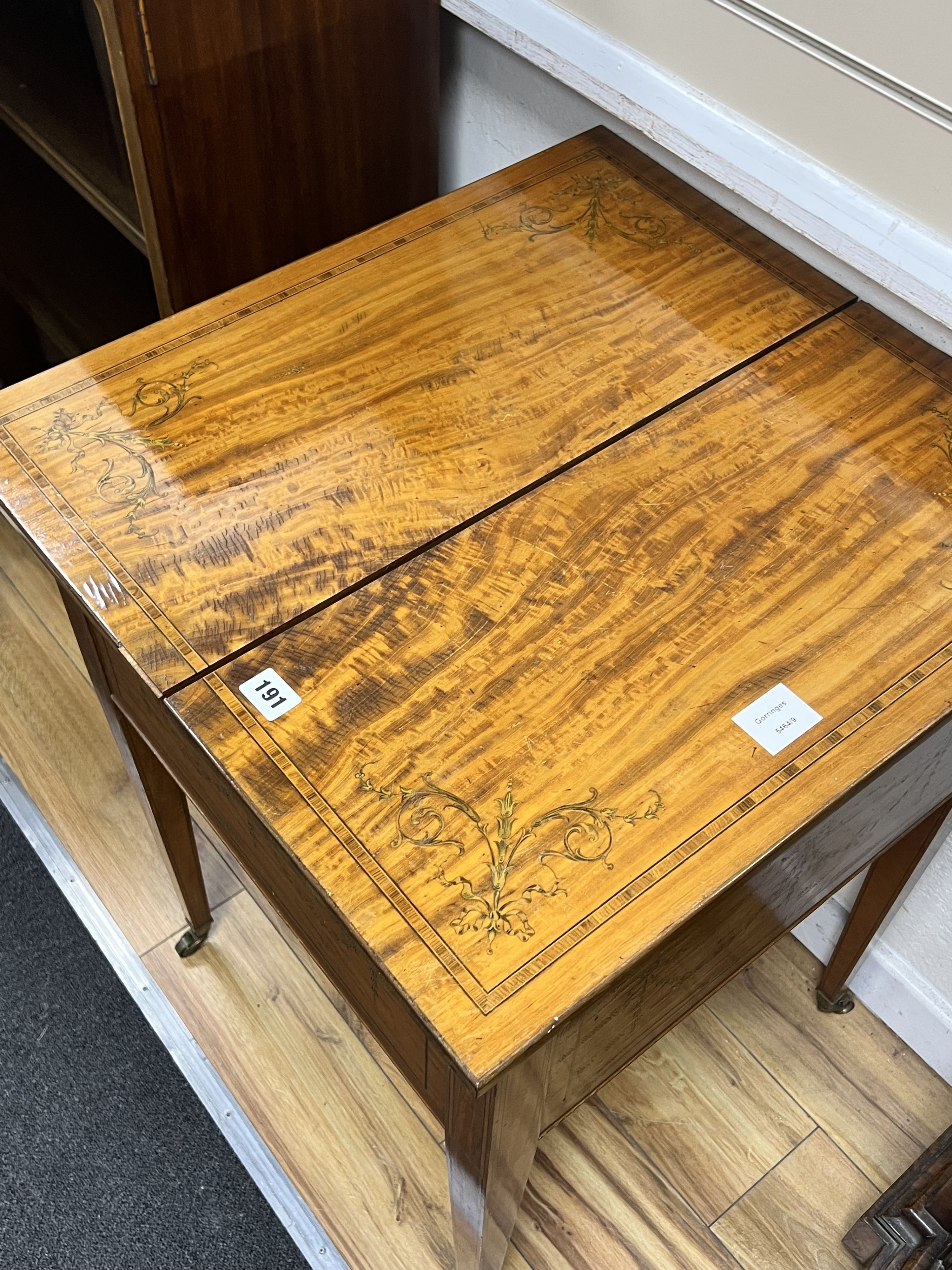 An Edwardian banded satinwood mahogany surprise drinks cabinet by Maple & Co, banded in kingwood and inlaid with husk festoons, divided opening top with rising interior, circa 1900., width 56cm depth 59cm height 78cm